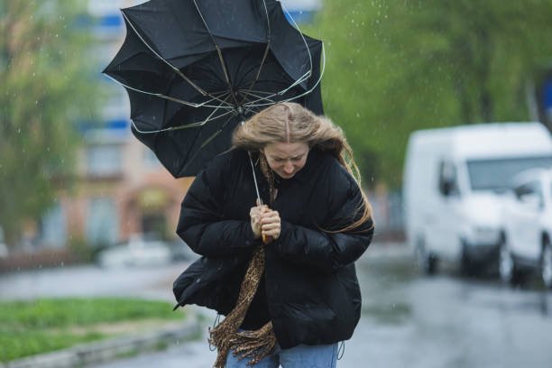 Women walking in the rain with an inverted umbrella. Demonstrating the importance of a quality umbrella